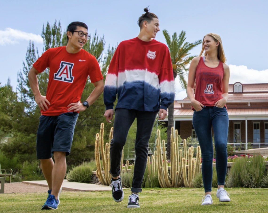 group of students wearing red and blue walking on a college campus